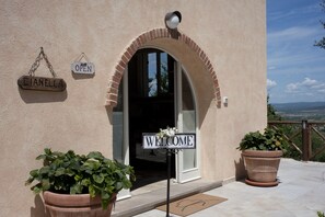 A building entrance with a 'Welcome' sign, 'Cianella' sign, and a 'Open' sign. - La Cianella (Scarlino)