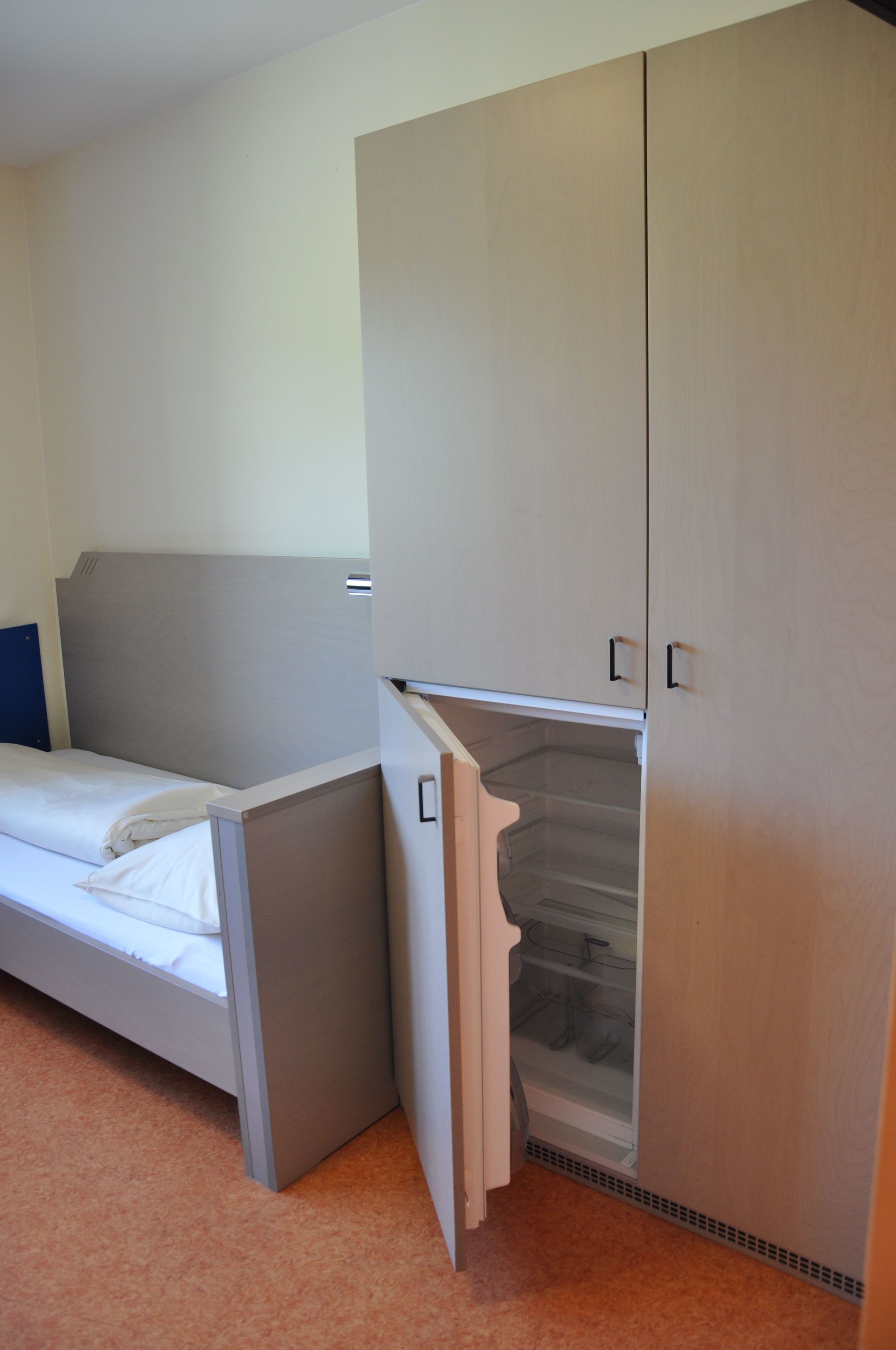 Een slaapkamer met een bed, een kledingkast en een inbouwkast.