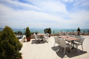 Eine Dachterrasse mit Sitzgelegenheiten und Meerblick.