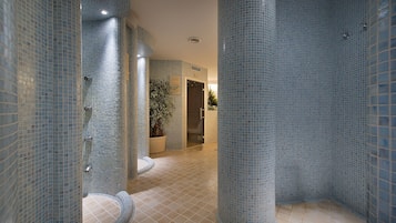 Experience the serene ambiance of this bathroom, featuring a unique mosaic tile design and a curved floor layout.