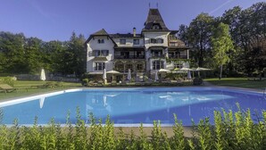 A large, two-story building with a swimming pool in front. - Landhaus Koller (Gosau)