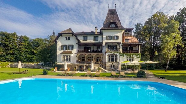 A large, multi-story building with a swimming pool in front. - Landhaus Koller (Gosau)