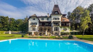Un grand immeuble à plusieurs étages, avec une piscine devant.