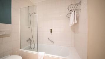 Un baño moderno con ducha de vidrio, una bañera independiente y un inodoro.