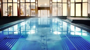 A large indoor swimming pool with a clear view of the surrounding area, including windows and a reception desk. - Alpen Adria Hotel & Spa (Hermagor-Pressegger See)