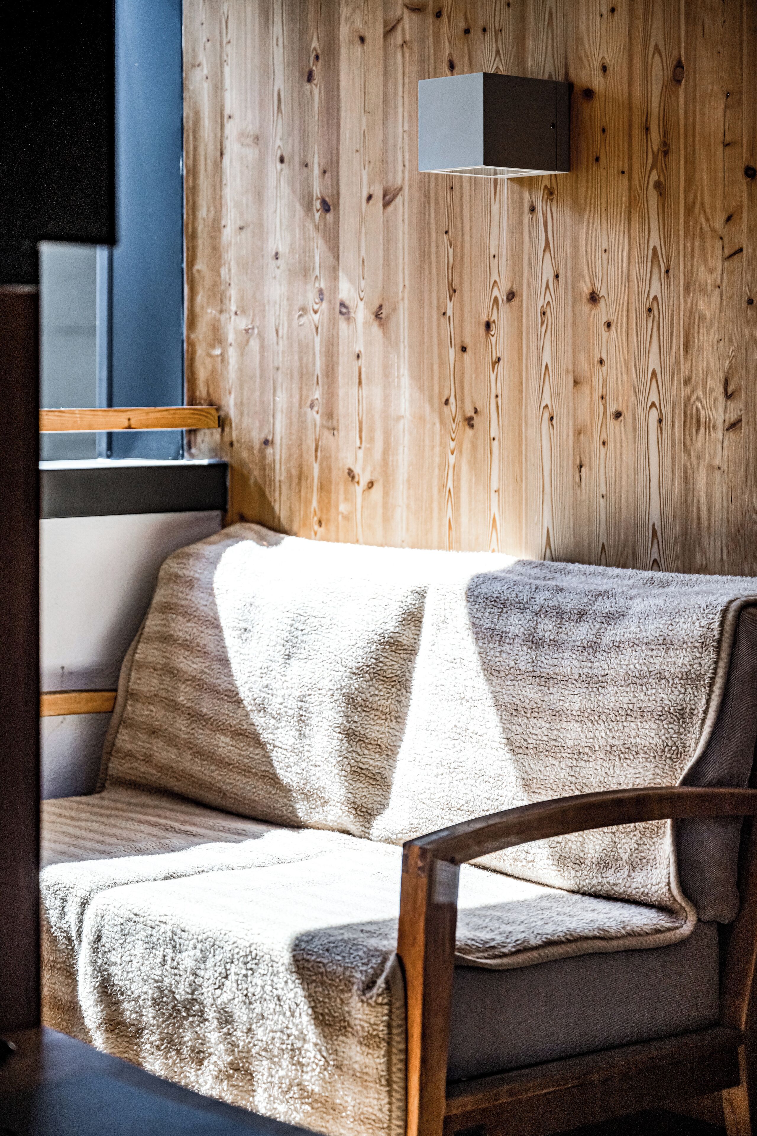 Ein gemütliches Zimmer mit einer Holzwand, einer Couch und einem kleinen Tisch.
