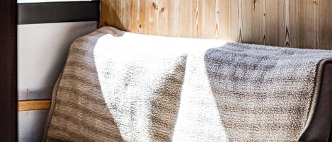 Una habitación acogedora con un muro de madera, un sofá y una mesita.