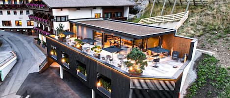 Un hotel moderno con un patio en la azotea que ofrece espacio para sentarse al aire libre y vistas del paisaje circundante.