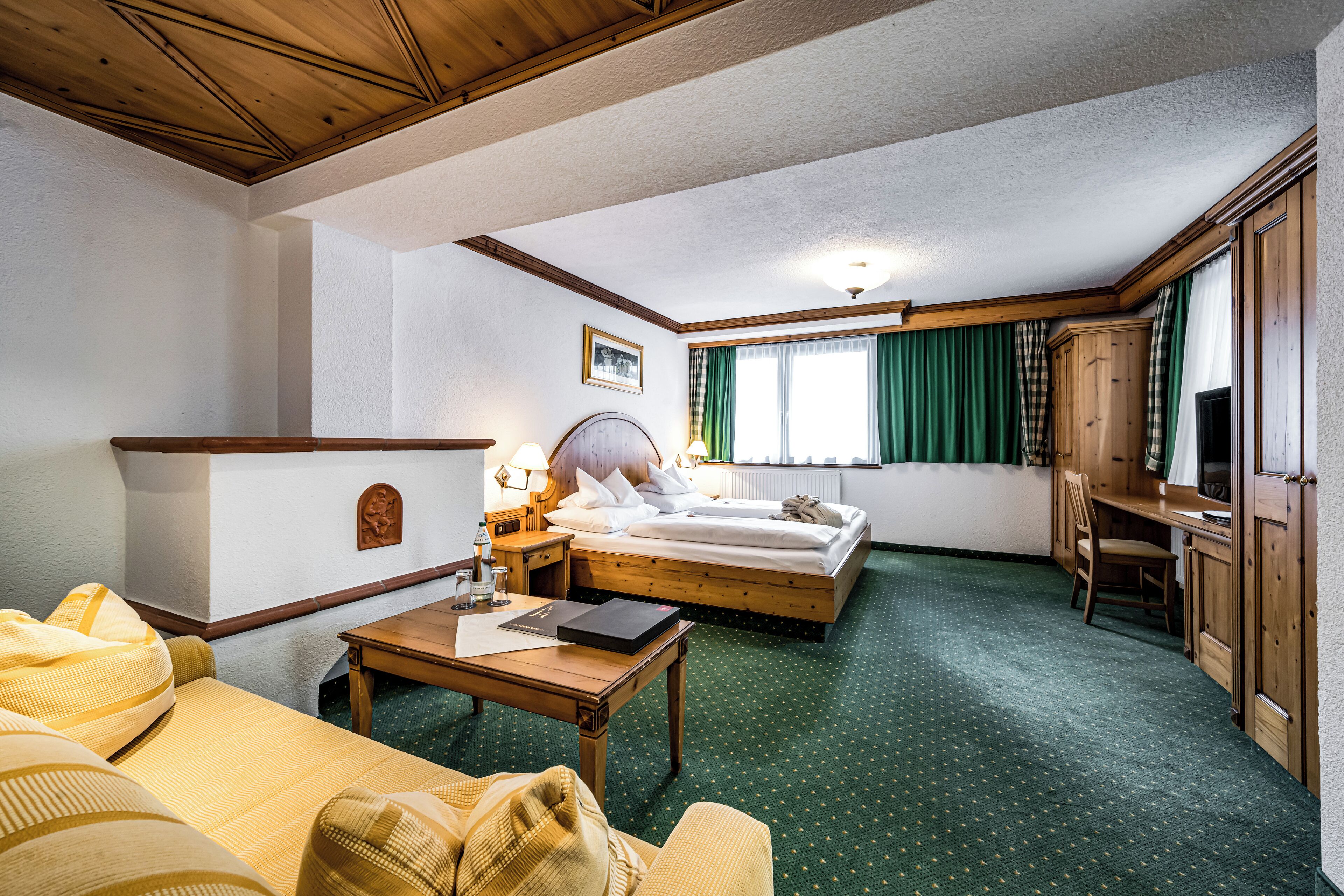 Une chambre d’hôtel comprenant un lit, un bureau, une chaise, un canapé et une petite table.