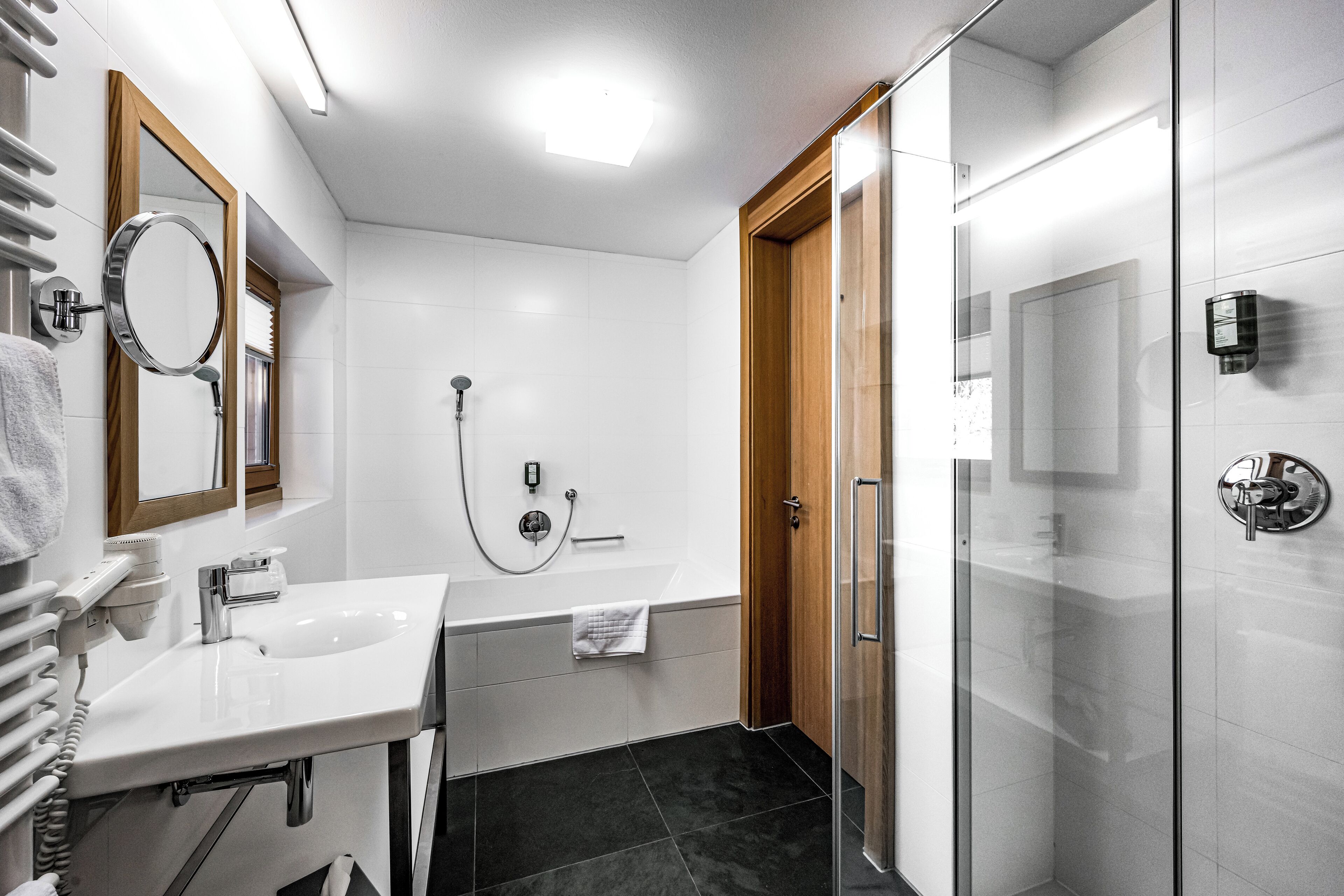 A modern bathroom with a white sink, mirror, and shower.