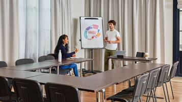 A conference room with a whiteboard, a presentation, and a laptop on a table.