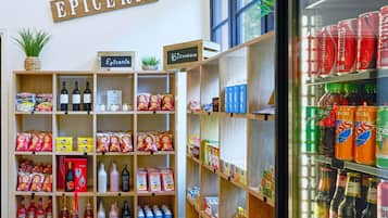A store interior with shelves stocked with snacks, beverages, and a sign reading "EPICERIE".