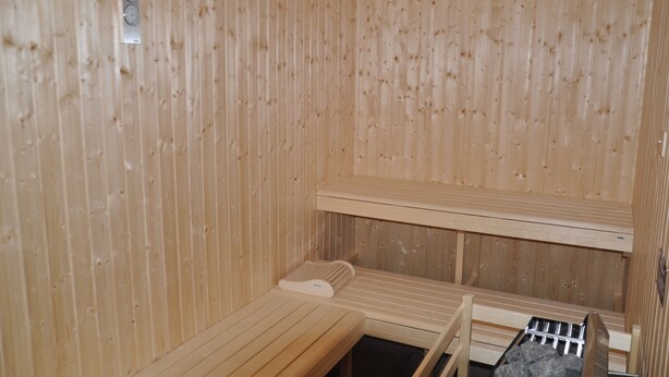 Eine Sauna mit Holzwänden und -bänken.