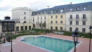 Ein Hotelinnenhof mit Swimmingpool, Kiosk und einer Reihe mehrstöckiger Gebäude.