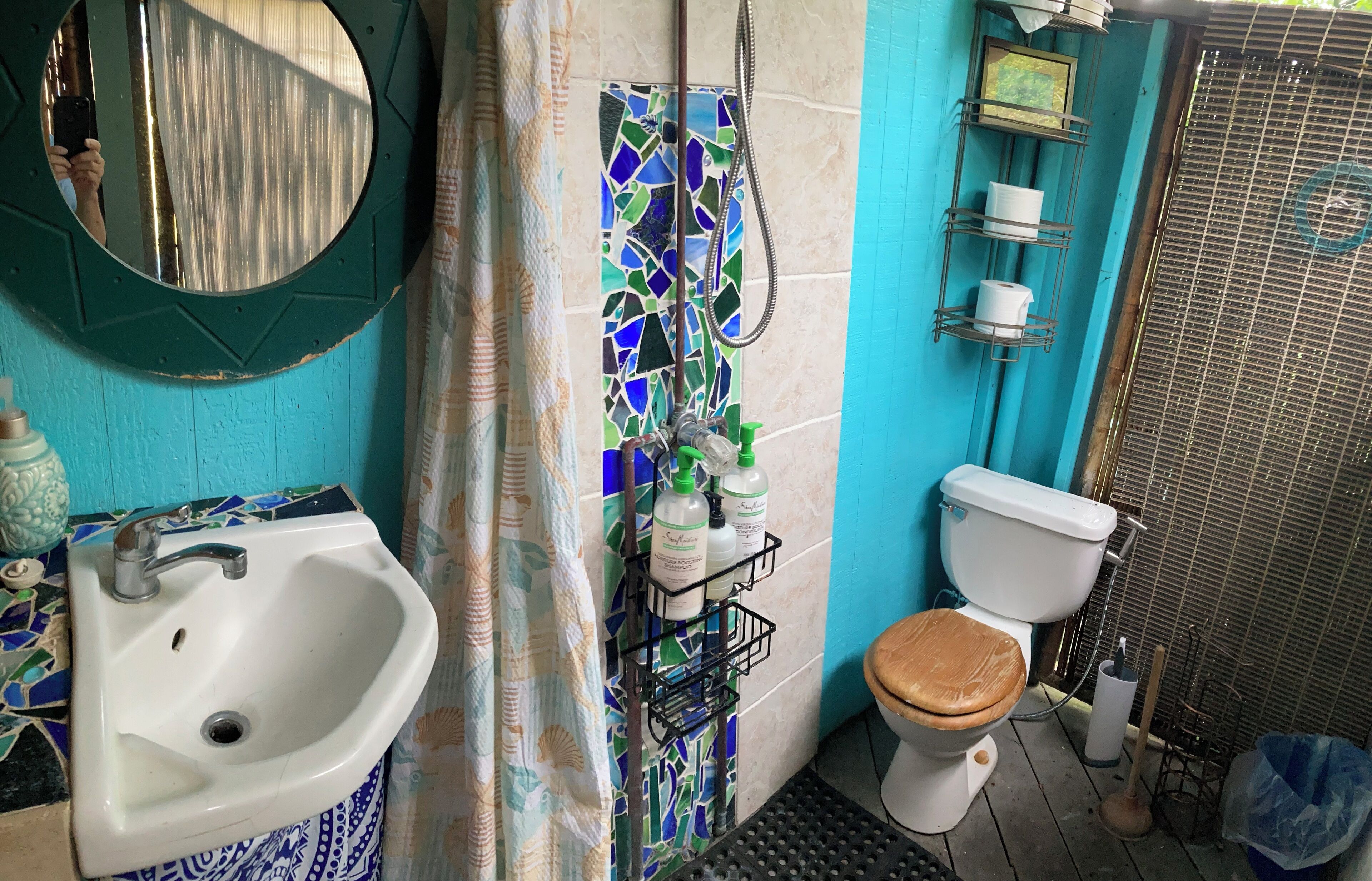 A bathroom with a sink, toilet, and shower area.