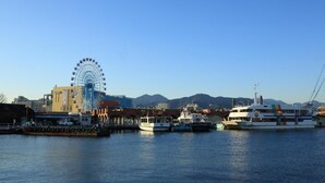 A waterfront area with a Ferris wheel, boats, and buildings. - Smile Hotel Shizuoka (Shizuoka)