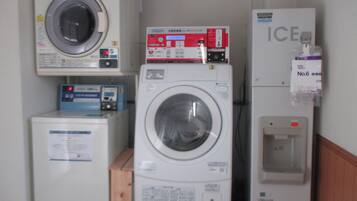 A laundry room with multiple washing machines and a refrigerator.