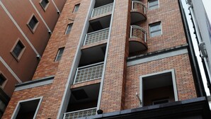 Un edificio de varios pisos con fachada de ladrillo, múltiples balcones y un diseño arquitectónico moderno.