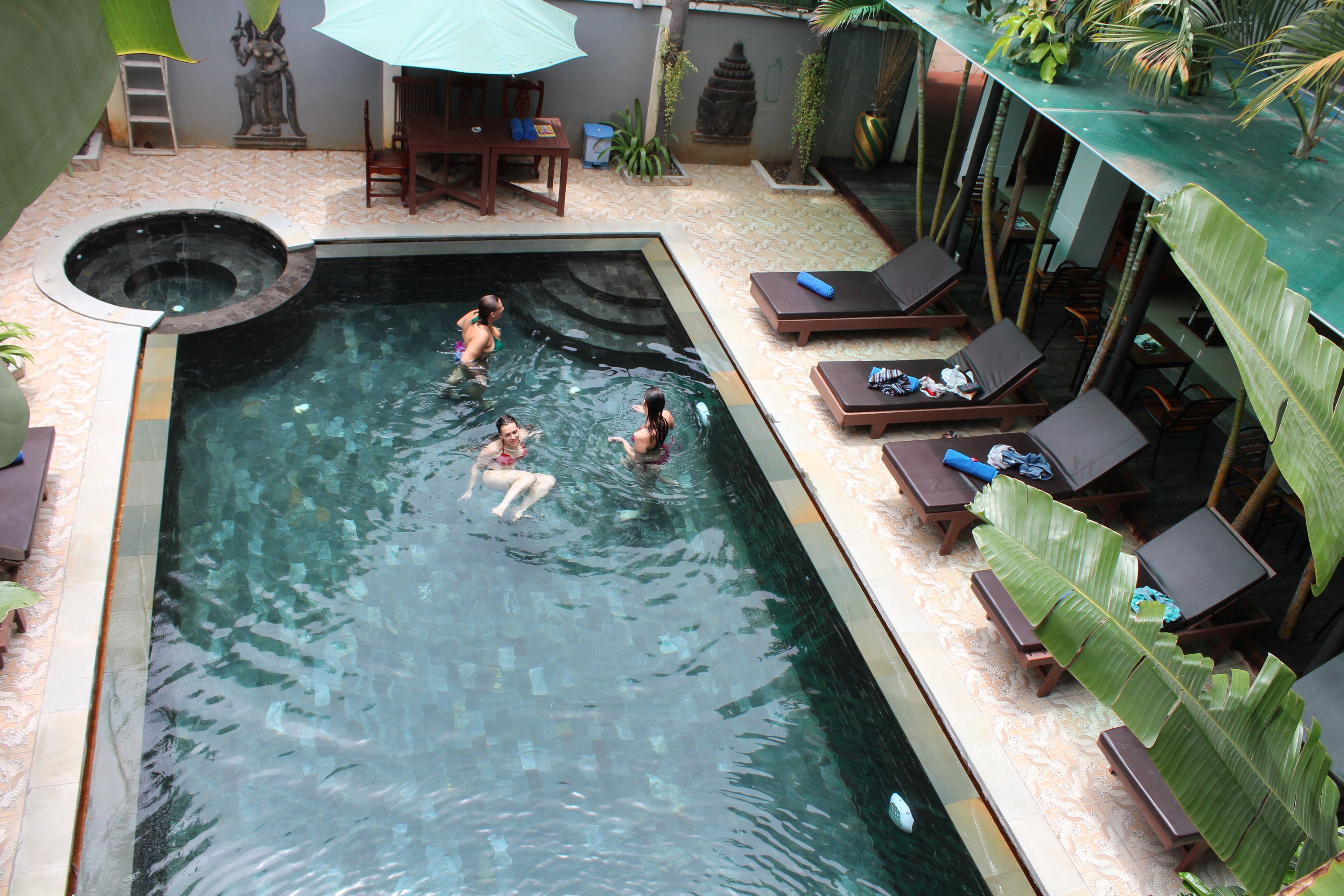 Ein Pool mit Liegestühlen und einer Whirlpool-Anlage.