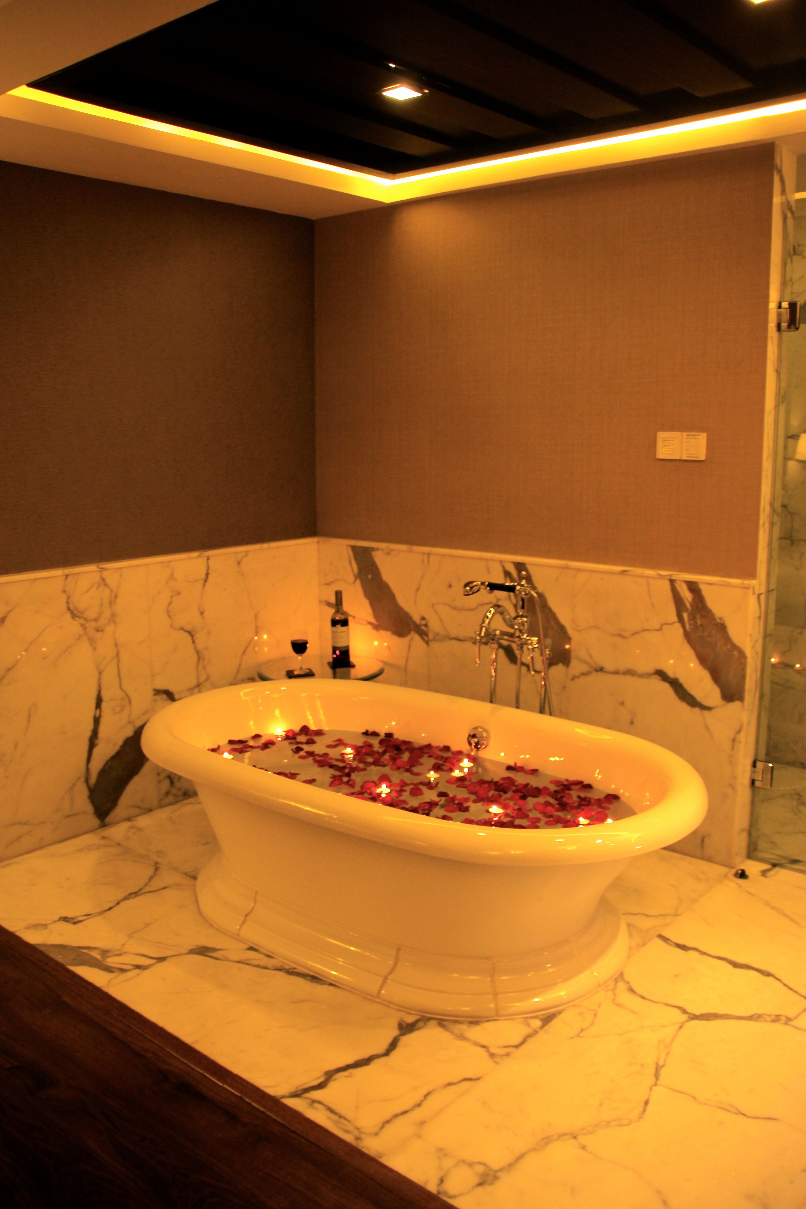 deluxe suite | bathroom | shower, rainfall showerhead, slippers, towels