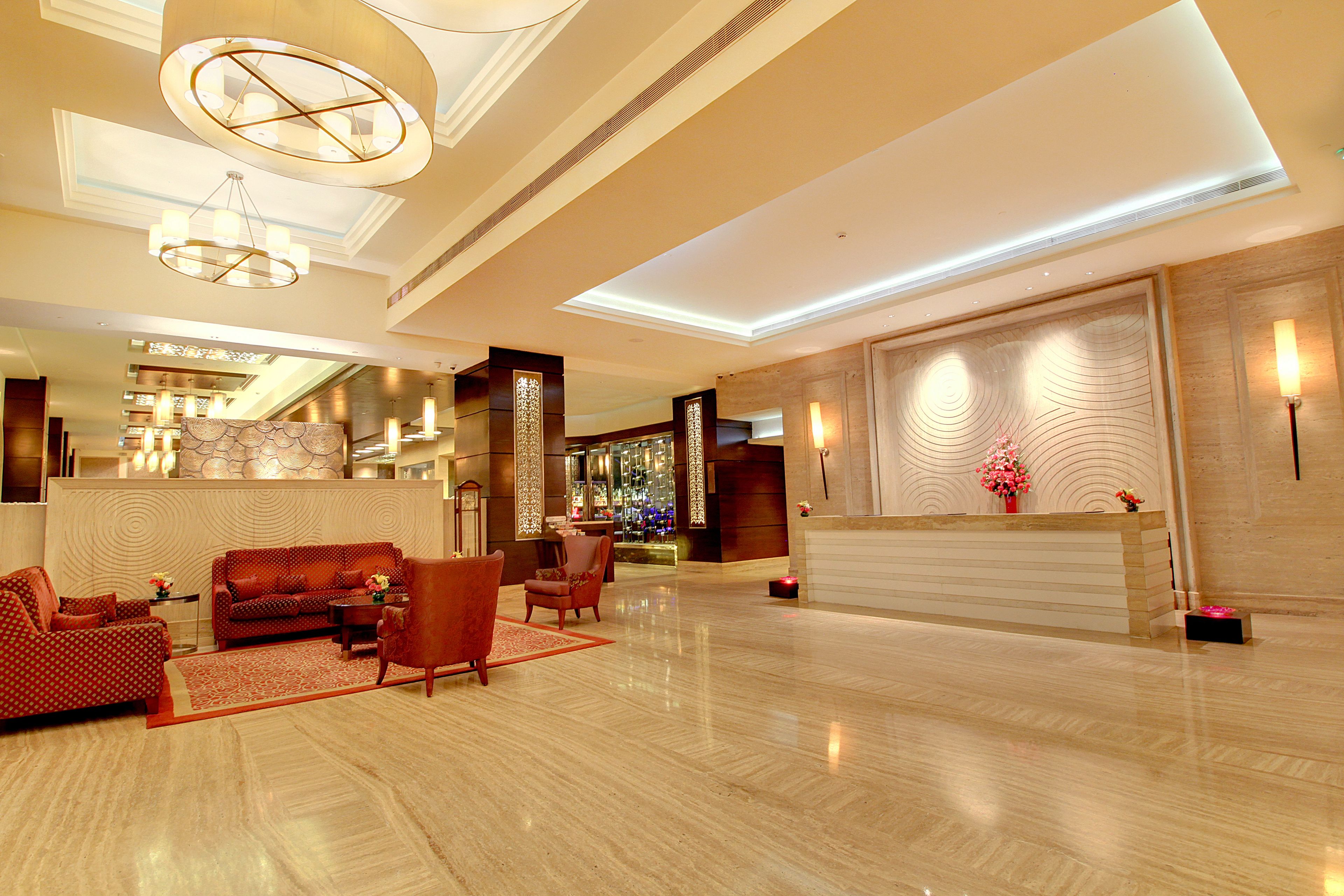 A spacious lobby with a reception desk, seating area, and a bar.