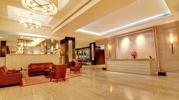 A spacious lobby with a reception desk, seating area, and a bar.