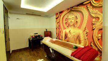 Features a large mural, a comfortable bed, and a small table with a vase of flowers.