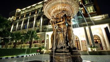 Un hotel con una gran escultura de fuente en primer plano.