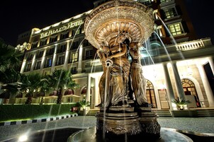 Un hotel con una gran escultura de fuente en primer plano.
