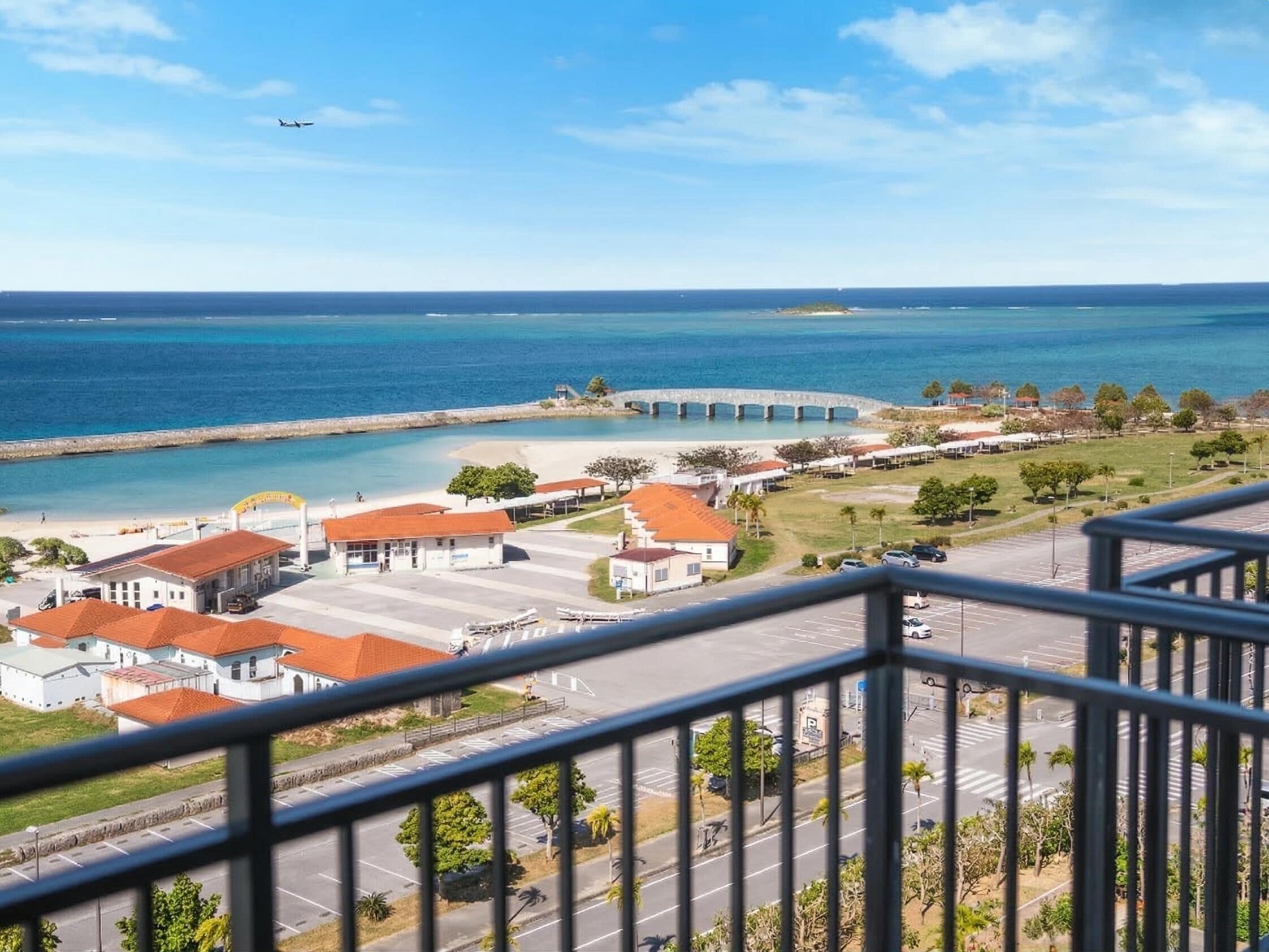 Un pueblo costero con un puerto deportivo, edificios de tejados rojos y una vista despejada del mar.