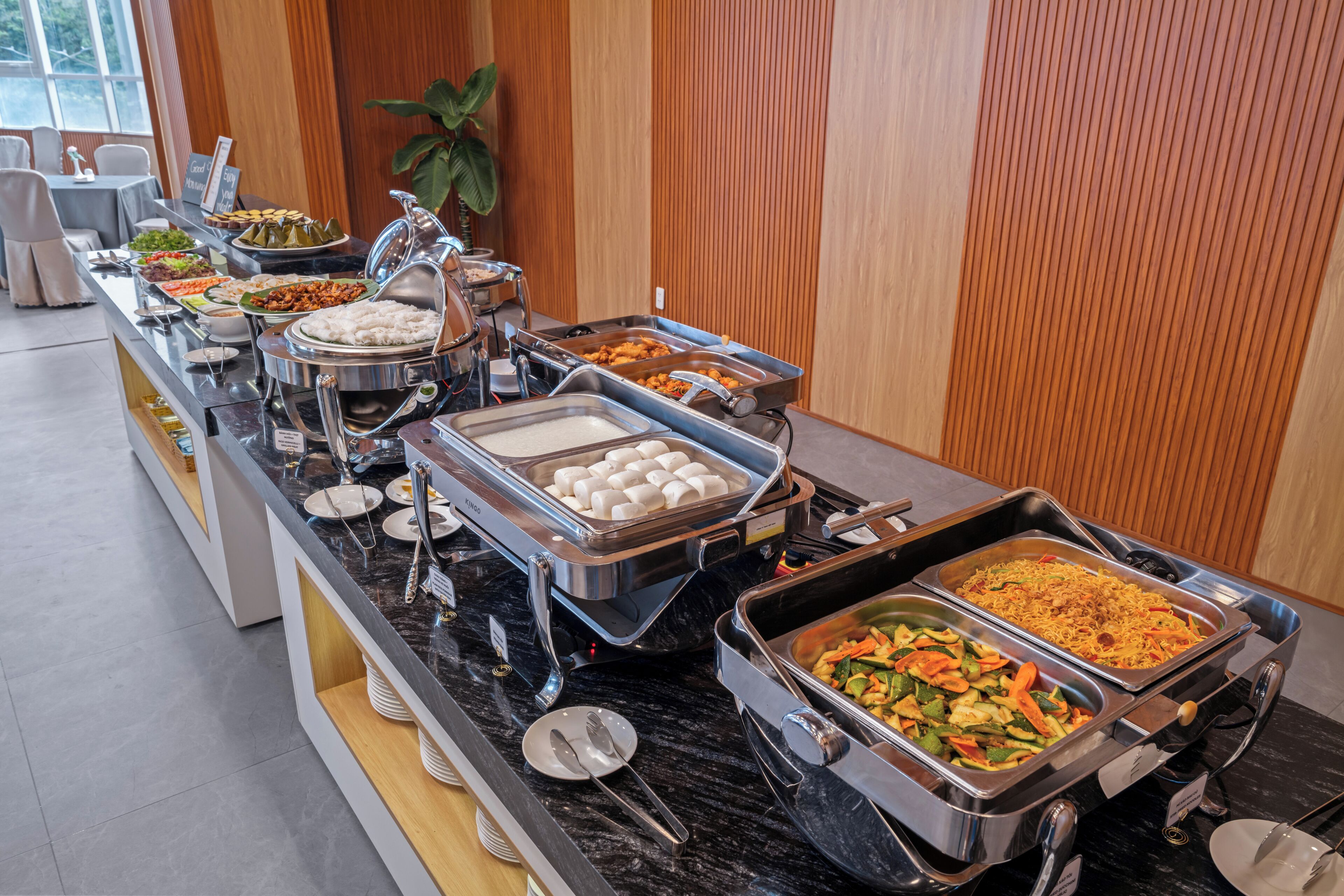 A buffet with various food options, including rice, vegetables, and meat dishes.