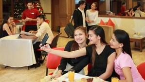 A dining area with tables, chairs, and a Christmas tree in the background. - Paladin Hotel (Baguio)