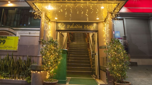 The exterior of the Paladin Hotel with a sign, entrance, and decorative lights. - Paladin Hotel (Baguio)