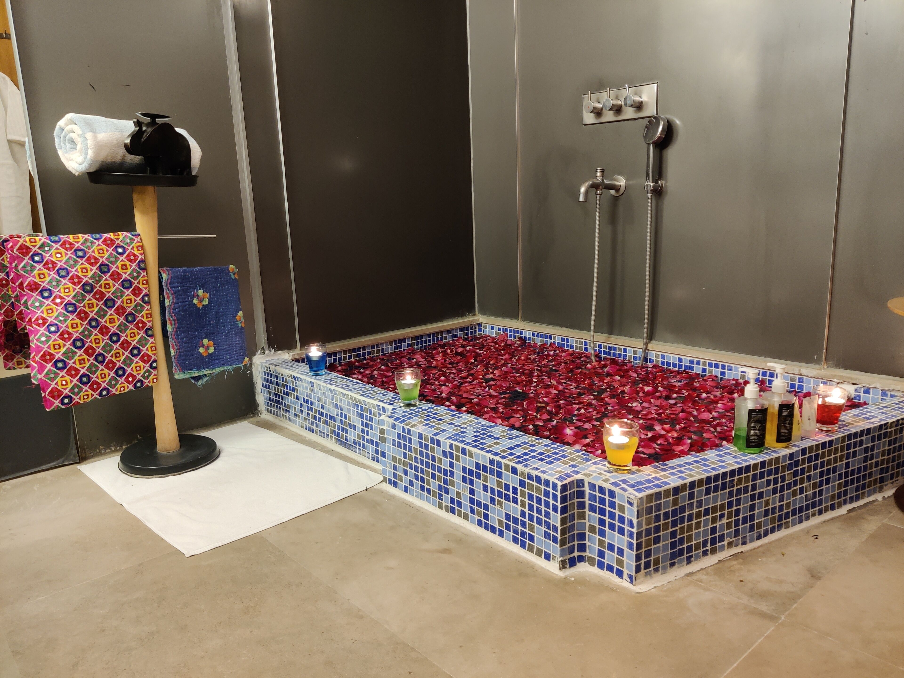 Une salle de bain avec une baignoire carrelée, un porte-serviettes et un espace douche.