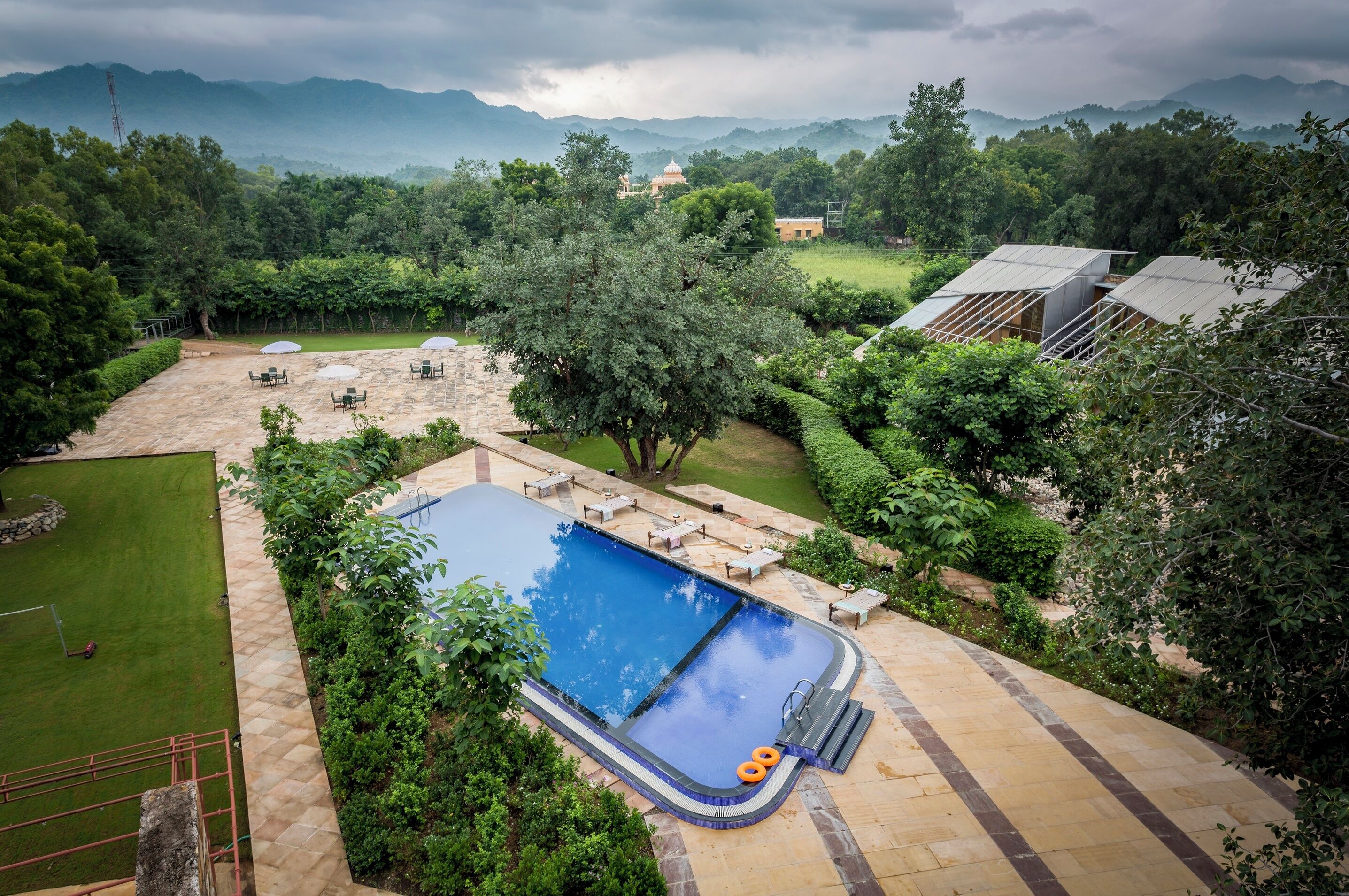 Una piscina al aire libre, sillones reclinables de piscina
