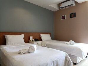 A hotel room with two beds, white bedding, a wooden headboard, a nightstand with a phone and a lamp, and an air conditioning unit on the wall. - JL Bangkok (Bangkok)