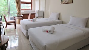 A hotel room with two beds, a small kitchenette, a dining area, and a view of greenery outside. - JL Bangkok (Bangkok)