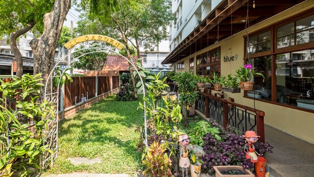 A courtyard with a sign reading "ST. GREGORY'S" and a building with a "blue9" sign. - JL Bangkok (Bangkok)