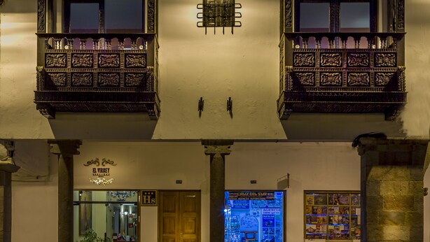 Rakennuksessa on koristeelliset parvekkeet, selkeästi näkyvä sisäänkäynti ja lasiovilla varustettu myymälä.