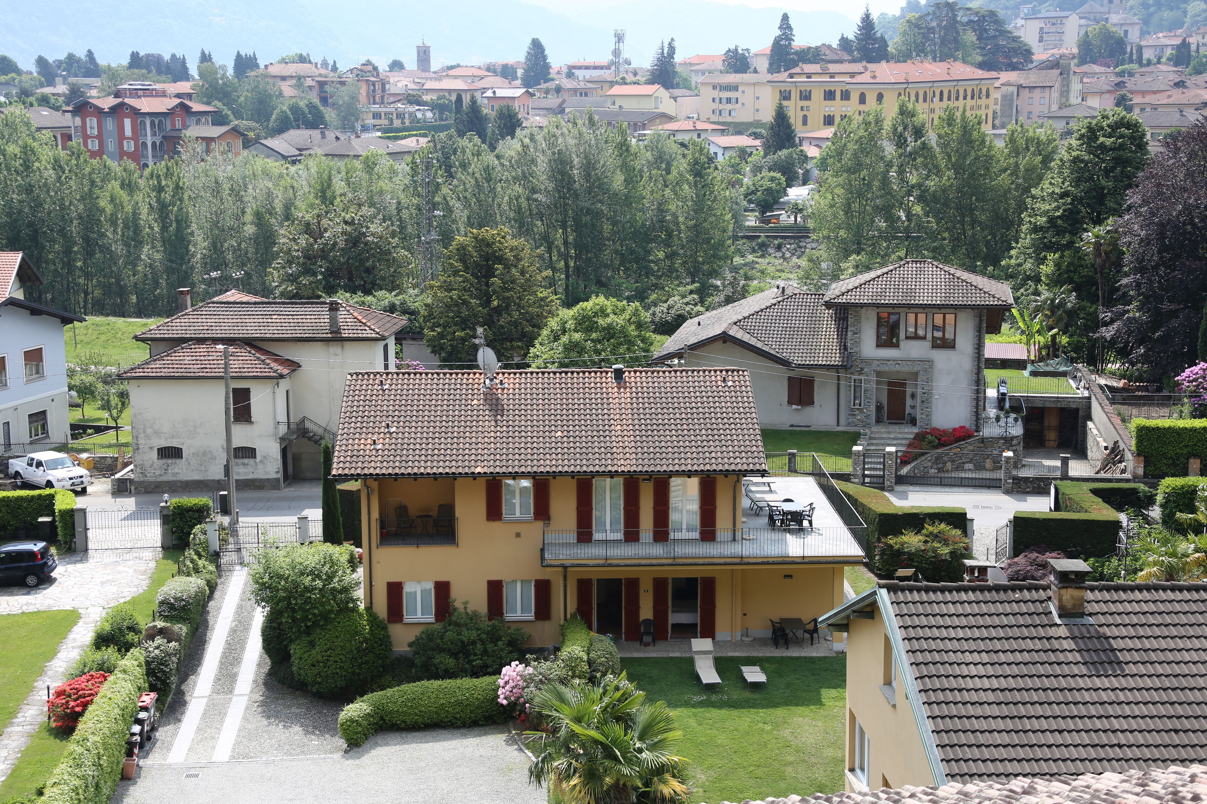 Un quartiere residenziale con case dotate di tetti in tegole rosse, un prato curato e una vista aperta sul vicinato.