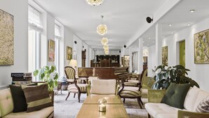 A spacious hotel lobby with a long reception desk, comfortable seating, and large windows allowing natural light. - Gl. Skovridergaard (Silkeborg)