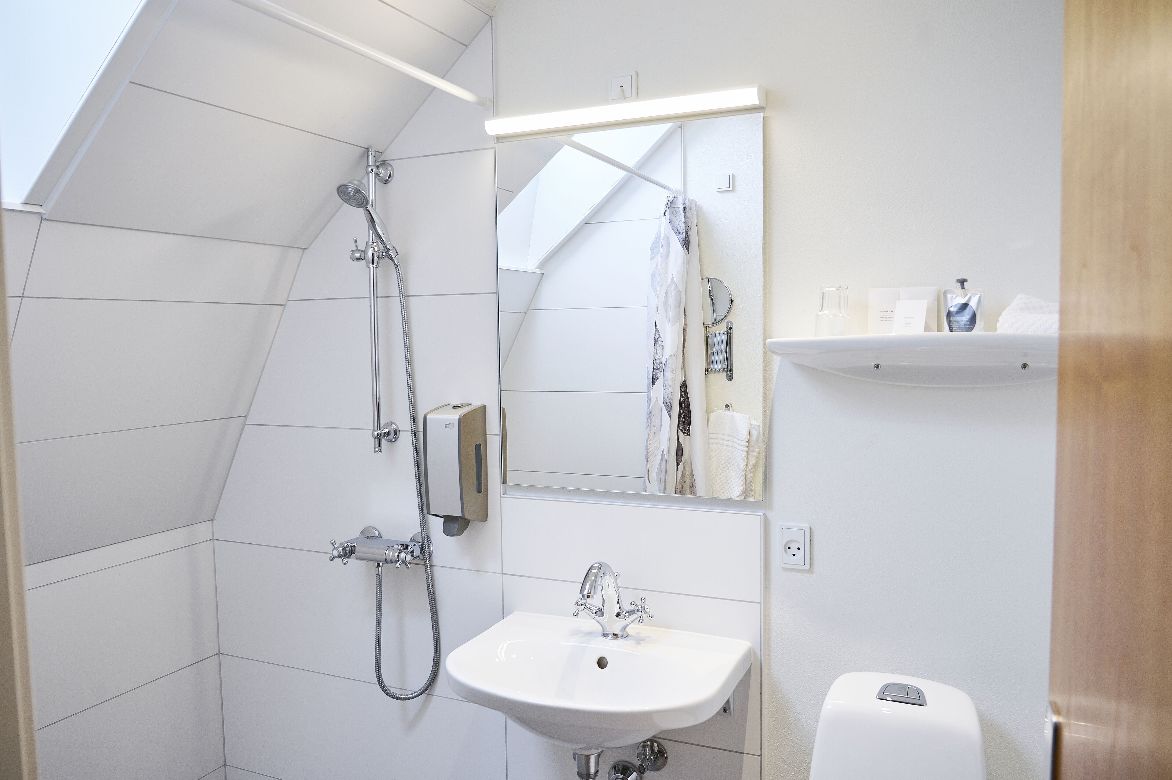 Une salle de bain moderne avec une douche, un lavabo et un miroir.