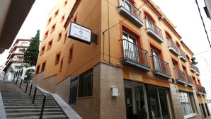 A multi-story building with a sign indicating it is a hotel. There are multiple balconies with railings, and the building has a tiled facade. - Royal Inn Aparthotel (Lloret de Mar)