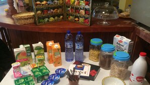A buffet table with various food and drink options including juices, milk, and condiments. - Royal Inn Aparthotel (Lloret de Mar)