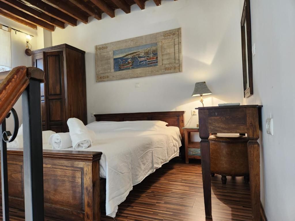 A bedroom with a wooden bed, a nightstand, a lamp, and a painting on the wall.