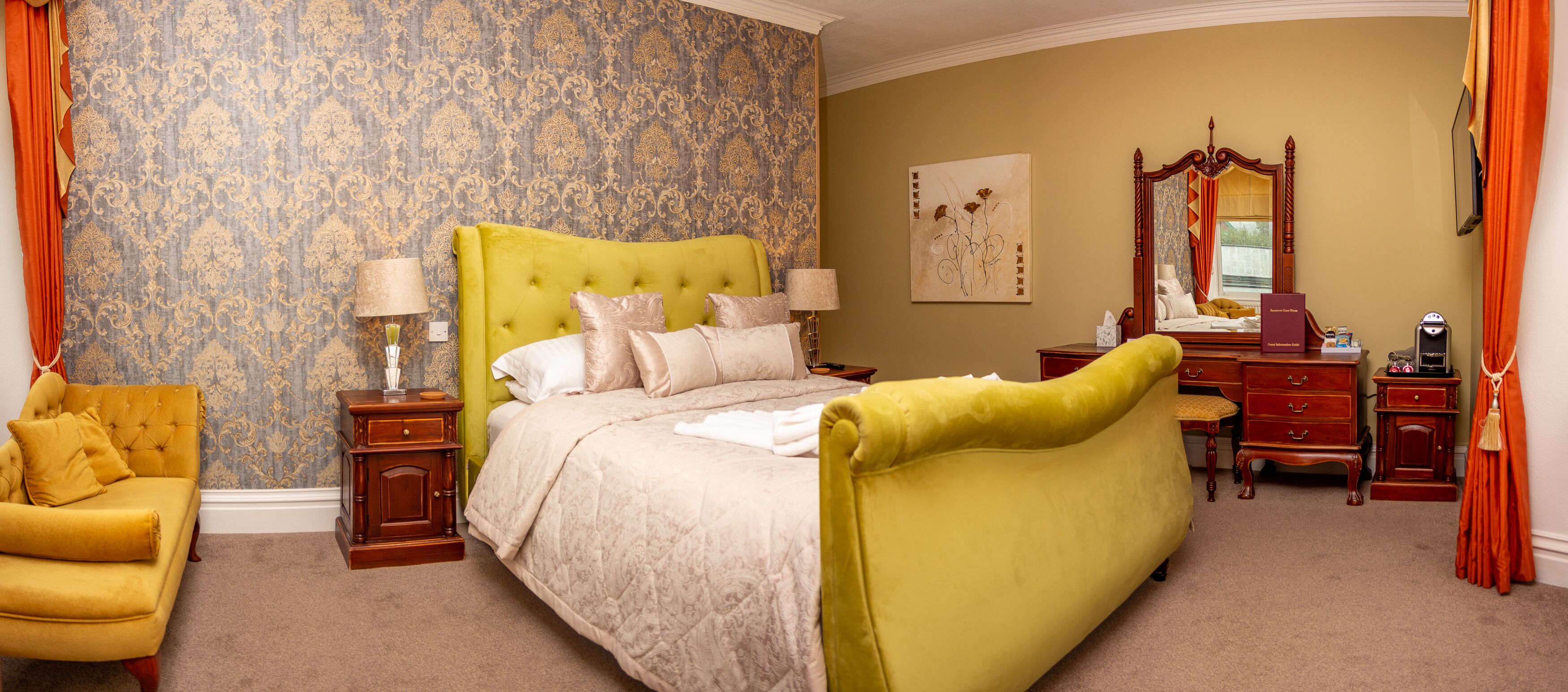 A bedroom with a large bed, a nightstand, a dresser, and a chair.