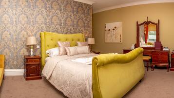A bedroom with a large bed, a nightstand, a dresser, and a chair.