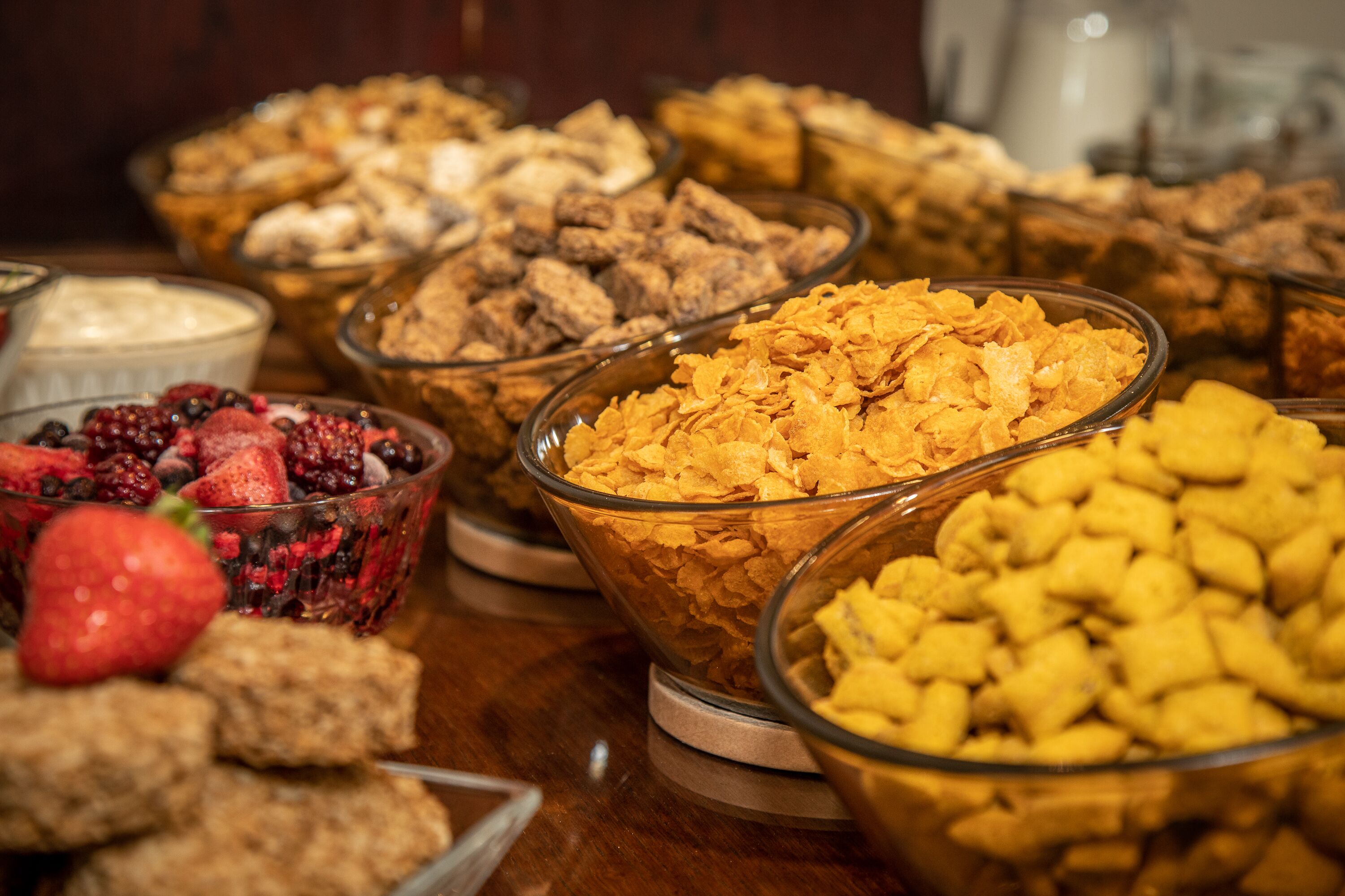 Un bufé con diversas opciones de comida, como cereales, frutas y otros bocadillos.