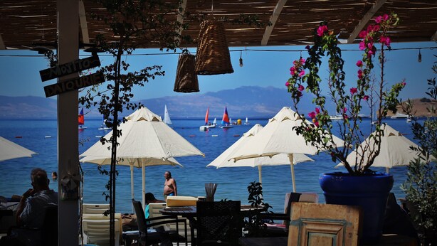 An outdoor seating area with umbrellas, a view of the sea, and a sign indicating 'MOJITO' and 'DAIQUER'. - Manuela Hotel (Bodrum)