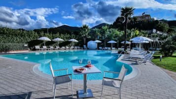 Una piscina al aire libre de temporada, sombrillas